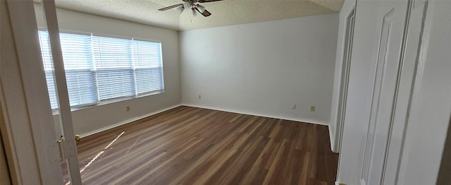 unfurnished room featuring dark wood finished floors, baseboards, a textured ceiling, and a ceiling fan