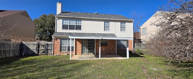 rear view of property with a patio area, a lawn, brick siding, and a fenced backyard