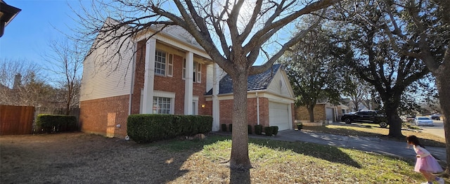 view of home's exterior featuring aphalt driveway, a garage, fence, and brick siding