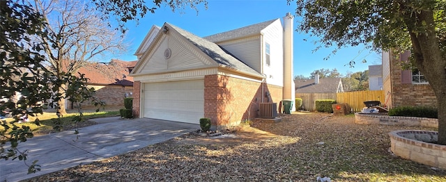 view of home's exterior featuring fence, driveway, a chimney, a garage, and brick siding