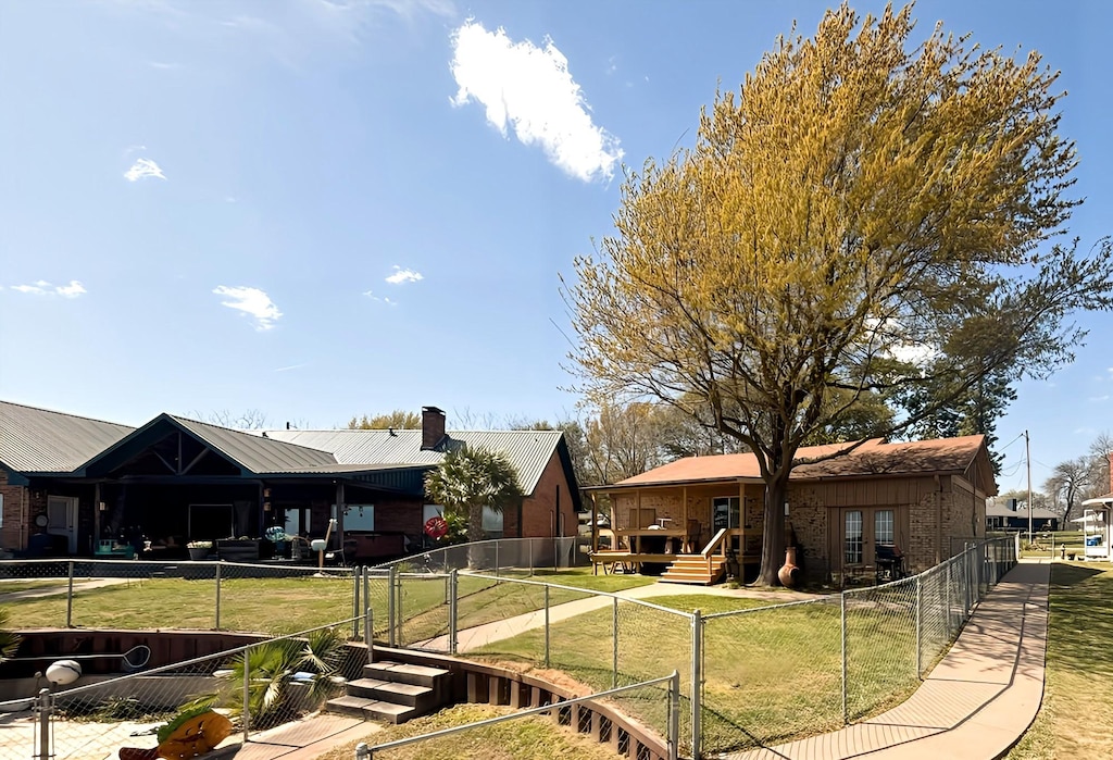 167 Seaside, Gun Barrel City, TX 75156 - back of house with a lawn, a fenced backyard, a chimney, and a gate