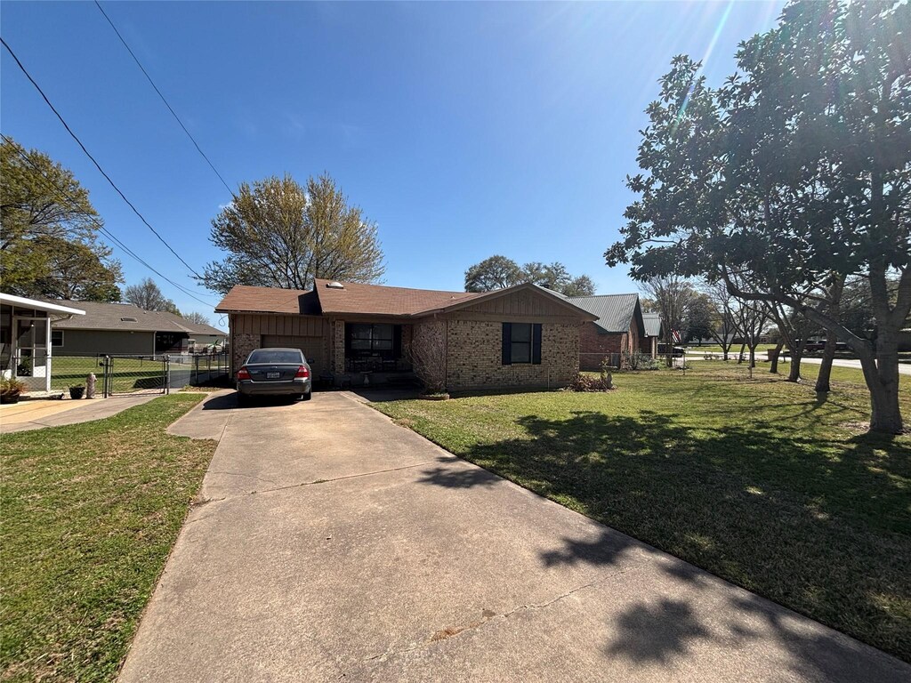 167 Seaside, Gun Barrel City, TX 75156 - ranch-style house with a front lawn, driveway, fence, brick siding, and a garage