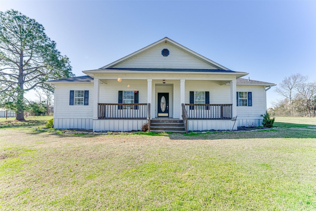 neoclassical / greek revival house with roof with shingles, a front lawn, and a porch