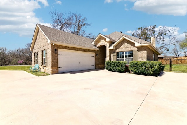 ranch-style home with concrete driveway, a chimney, stone siding, a garage, and fence