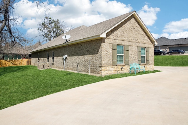 view of home's exterior featuring a yard, fence, and brick siding