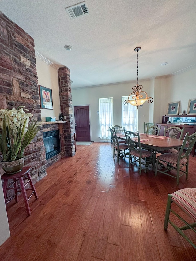 507 W 2nd St, Maypearl, TX 76064 - dining area with a fireplace, wood finished floors, crown molding, and a chandelier