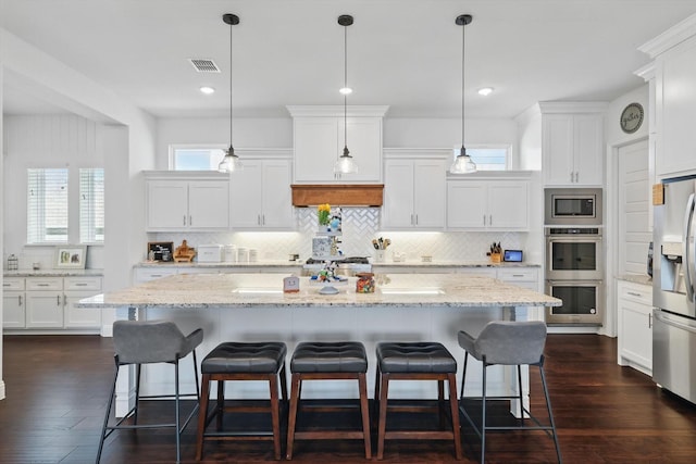 1208 S Pecan Pkwy, Northlake, TX 76247 - kitchen with stainless steel appliances, tasteful backsplash, visible vents, and white cabinets