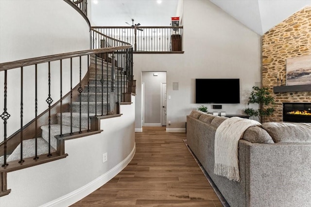 1261 Duke Dr, Prosper, TX 75078 - living room featuring baseboards, stairs, ceiling fan, high vaulted ceiling, and wood finished floors