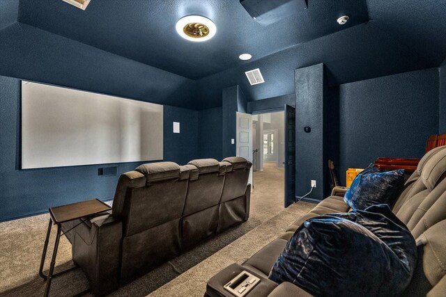 1261 Duke Dr, Prosper, TX 75078 - carpeted home theater featuring a textured wall, visible vents, and vaulted ceiling