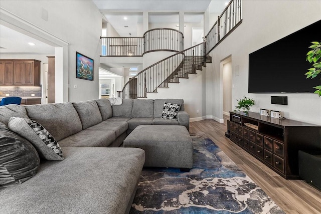 1261 Duke Dr, Prosper, TX 75078 - living room featuring a towering ceiling, wood finished floors, baseboards, and stairs