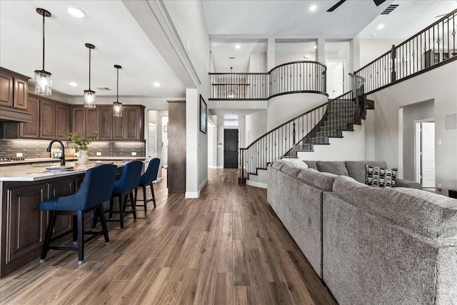 1261 Duke Dr, Prosper, TX 75078 - living room featuring dark wood-type flooring, stairway, baseboards, ceiling fan, and recessed lighting