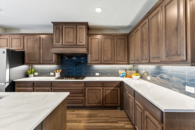 1261 Duke Dr, Prosper, TX 75078 - kitchen featuring dark wood-type flooring, appliances with stainless steel finishes, extractor fan, and backsplash