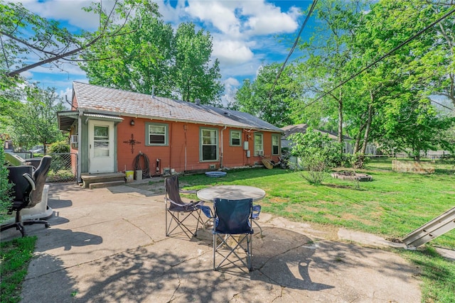 back of property with a patio area, a lawn, and fence