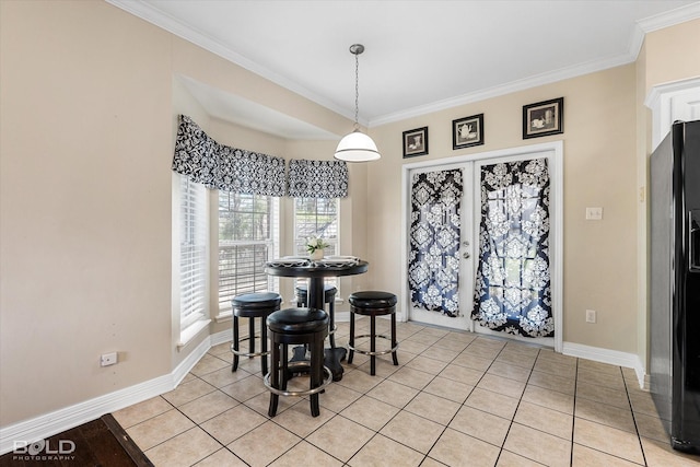 dining area with light tile patterned floors, baseboards, and crown molding