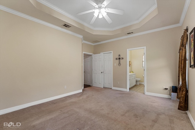 unfurnished bedroom featuring light carpet, baseboards, visible vents, and a raised ceiling