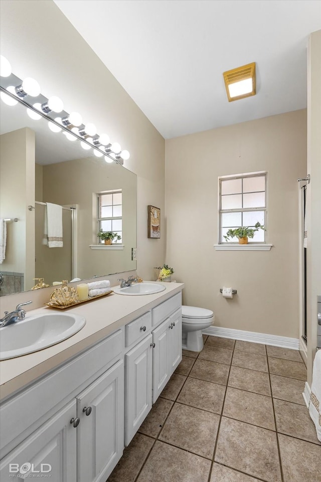 bathroom with a shower stall, toilet, tile patterned flooring, and a sink