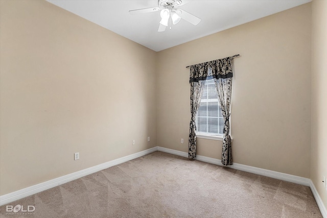 carpeted spare room featuring a ceiling fan and baseboards