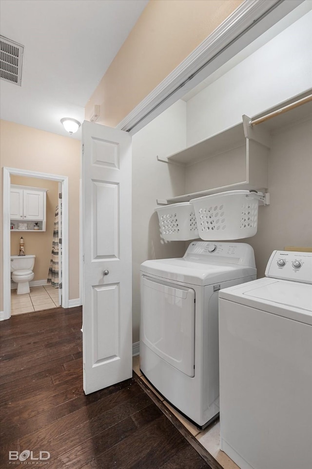 laundry area featuring visible vents, baseboards, wood finished floors, laundry area, and separate washer and dryer