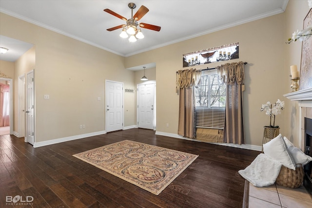 foyer entrance with crown molding, baseboards, a ceiling fan, and wood-type flooring