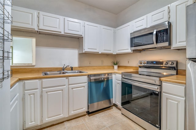 kitchen featuring white cabinetry, light countertops, a sink, and stainless steel appliances
