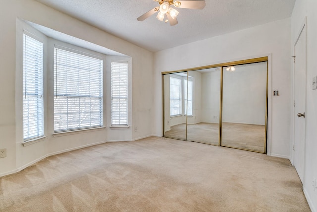 unfurnished bedroom featuring a closet, a ceiling fan, carpet flooring, and a textured ceiling