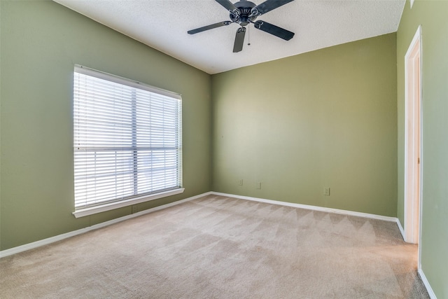 unfurnished room featuring carpet floors, baseboards, ceiling fan, and a textured ceiling