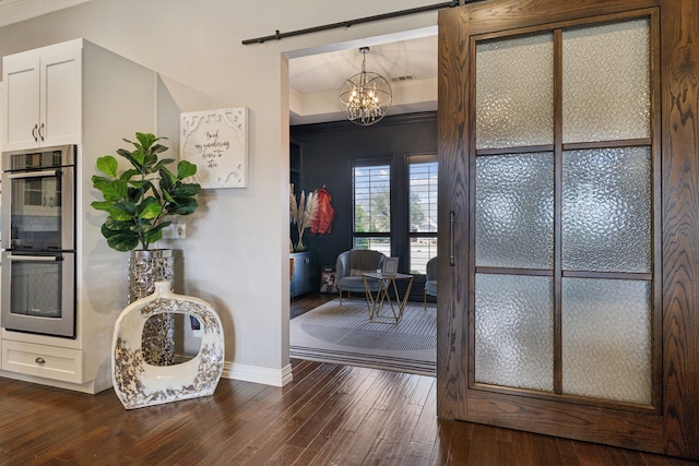 15961 Custer Trl, Frisco, TX 75035 - dining room featuring dark wood finished floors, a barn door, a chandelier, and ornamental molding