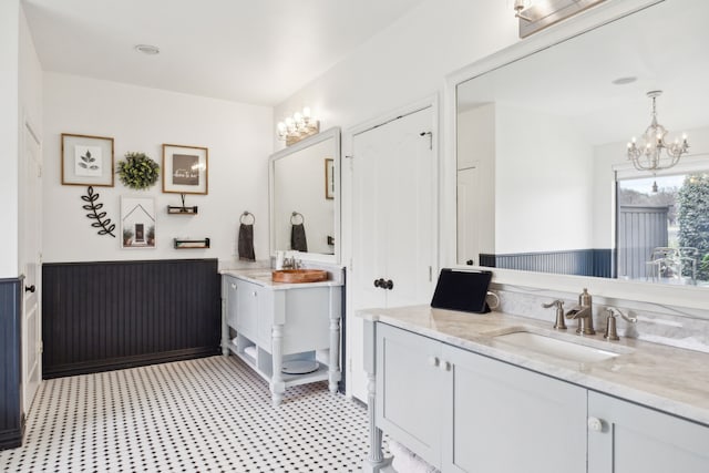 15961 Custer Trl, Frisco, TX 75035 - full bathroom with two vanities, a chandelier, and tile patterned floors