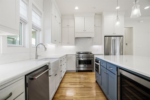 613 E Wall St, Grapevine, TX 76051 - kitchen featuring white cabinets, high quality appliances, wine cooler, and blue cabinetry