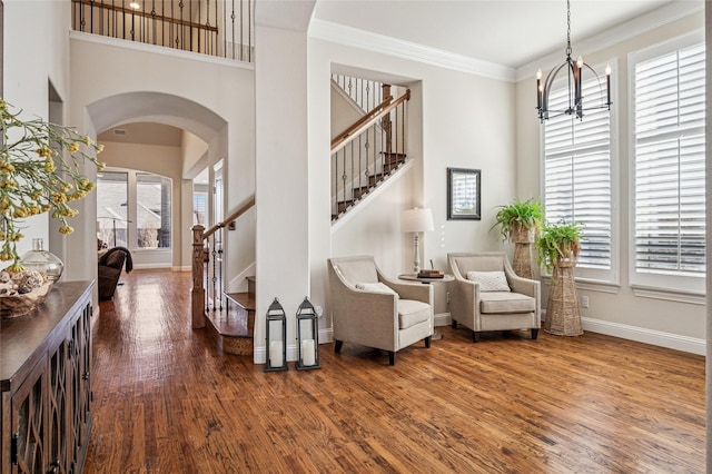 908 Champions Ct, Roanoke, TX 76262 - living area featuring stairway, wood finished floors, arched walkways, a chandelier, and a towering ceiling
