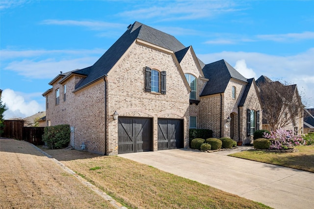 908 Champions Ct, Roanoke, TX 76262 - french country style house with brick siding, concrete driveway, an attached garage, and roof with shingles