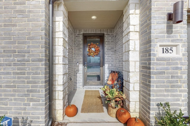 doorway to property with brick siding