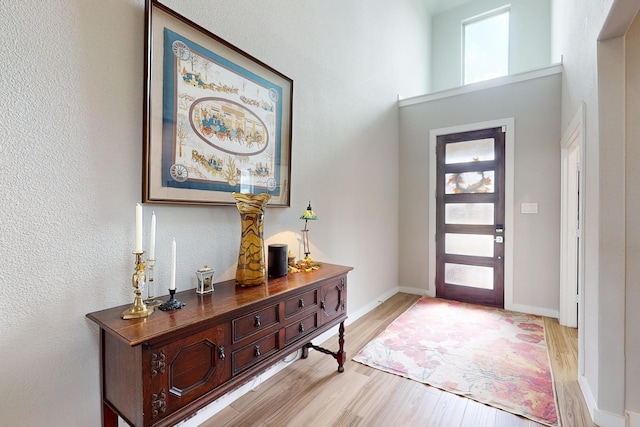 entrance foyer with light wood-style floors, baseboards, and a healthy amount of sunlight