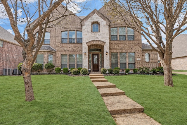 1217 Avondale Dr, Murphy, TX 75094 - view of front of home featuring brick siding, a front lawn, stone siding, and central air condition unit