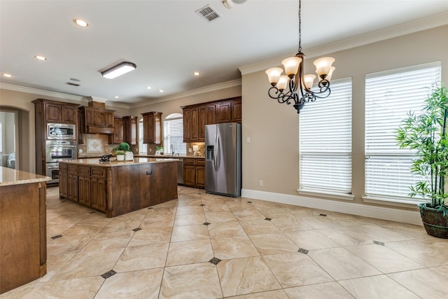 1217 Avondale Dr, Murphy, TX 75094 - kitchen featuring stainless steel appliances, a chandelier, ornamental molding, tasteful backsplash, and a kitchen island