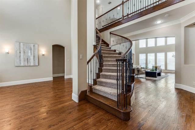 1217 Avondale Dr, Murphy, TX 75094 - stairway featuring a towering ceiling, arched walkways, wood finished floors, baseboards, and ornamental molding