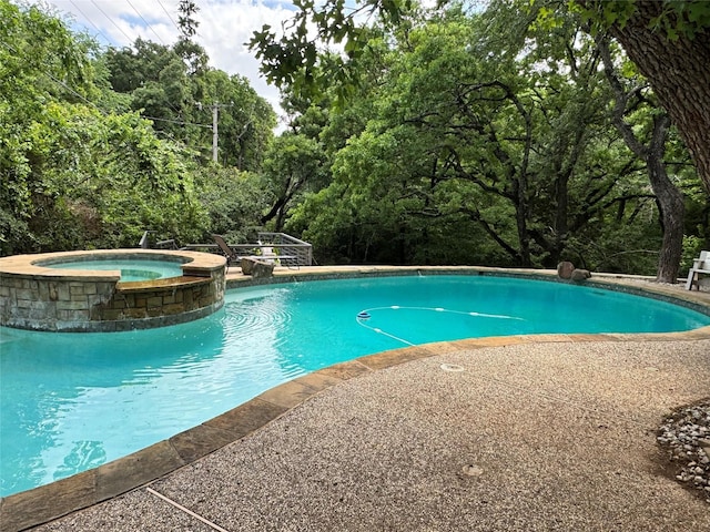 view of swimming pool with a pool with connected hot tub
