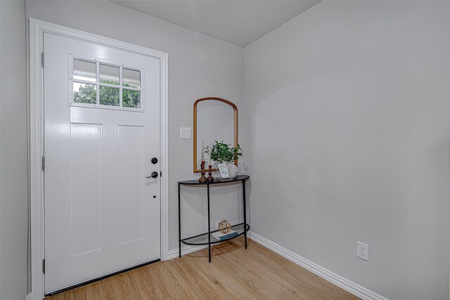 foyer with baseboards and light wood-type flooring