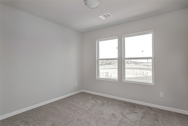 unfurnished room featuring baseboards, carpet flooring, and visible vents