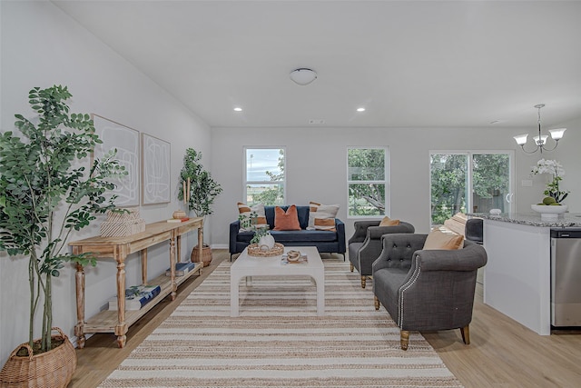 living room featuring a notable chandelier, a wealth of natural light, and light wood finished floors