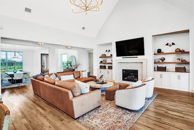 4909 Cheshire Ln, Parker, TX 75002 - living room with a chandelier, a fireplace, wood finished floors, built in features, and visible vents