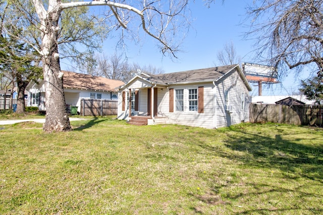 ranch-style house featuring fence and a front yard