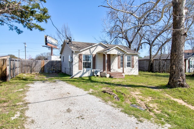 bungalow-style house with fence and a front lawn