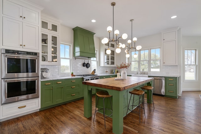 kitchen featuring butcher block counters, appliances with stainless steel finishes, and green cabinetry