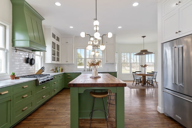 kitchen with wooden counters, appliances with stainless steel finishes, white cabinetry, premium range hood, and green cabinetry