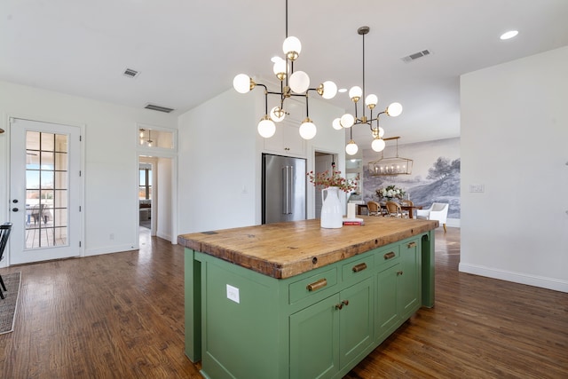 kitchen featuring green cabinets, high end fridge, butcher block counters, and visible vents