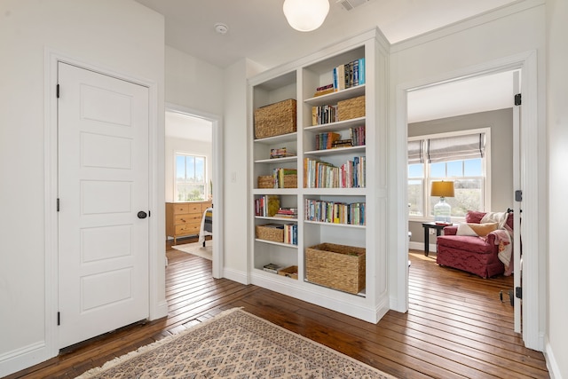 sitting room with dark wood finished floors, a healthy amount of sunlight, and baseboards