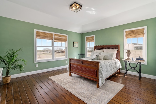 bedroom featuring hardwood / wood-style floors, baseboards, and multiple windows