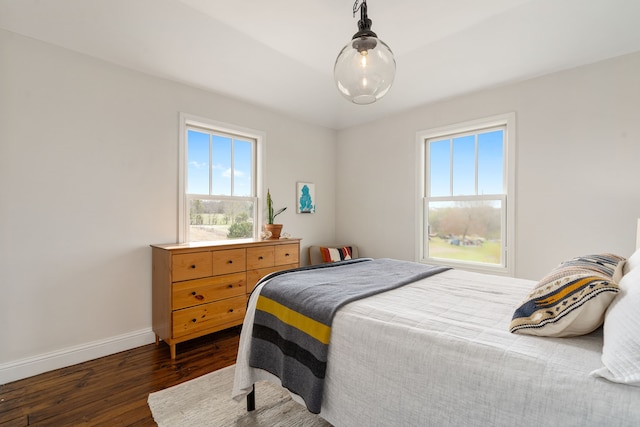 bedroom with baseboards and dark wood-type flooring