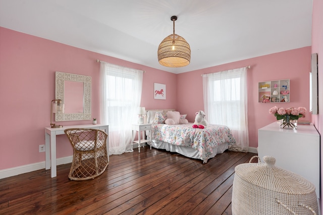 bedroom featuring baseboards, multiple windows, and hardwood / wood-style floors